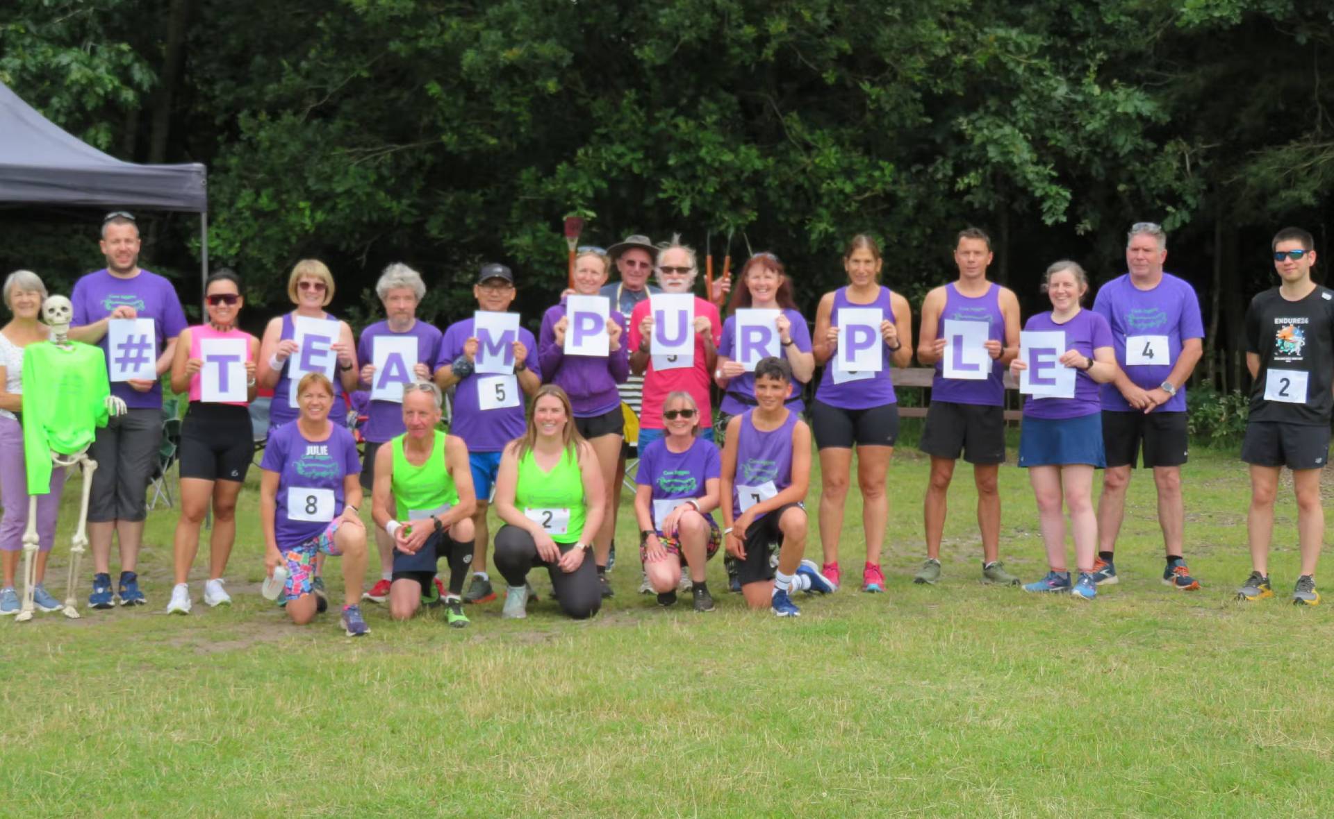 Cove Joggers members together holding signs spelling Team Purple.
